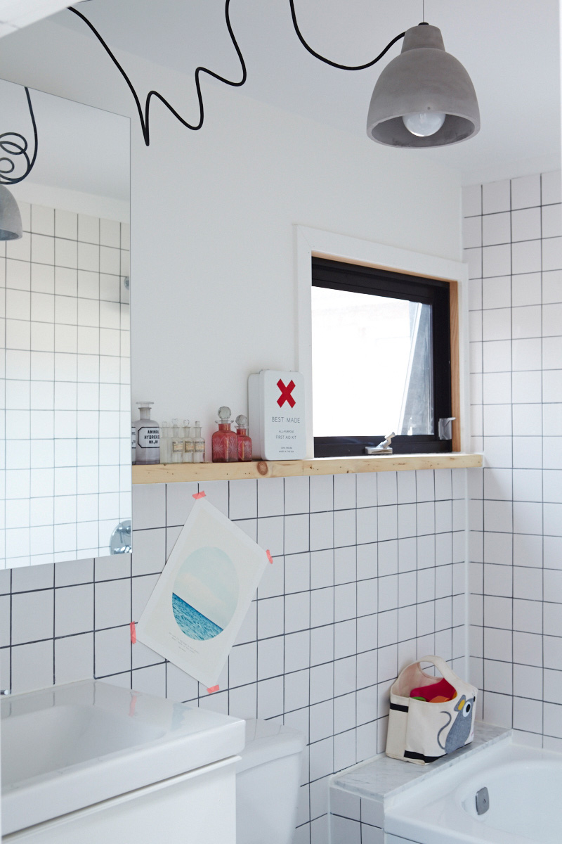 3 Go graphic. Hardware-store tile and black grout is installed graphic effect. Pendant, Home Depot; medicine cabinet, IKEA; window by Delta. Photo by Naomi Finlay.