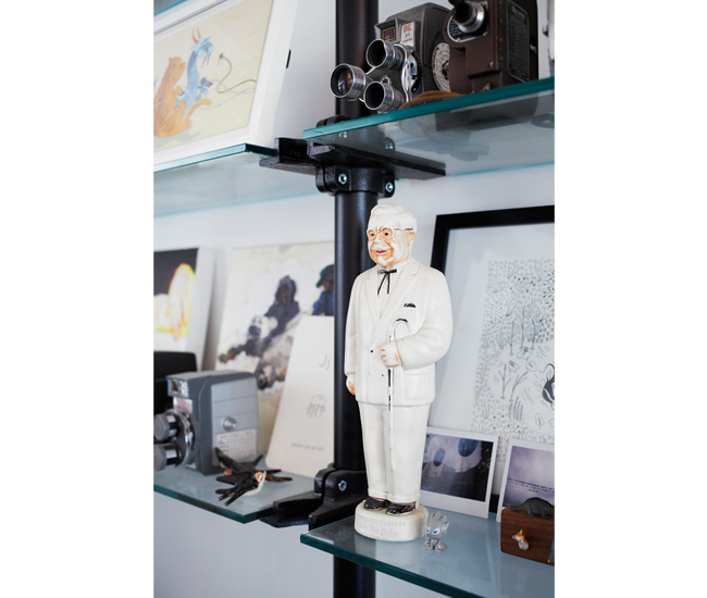 Colonel Sanders stands
among figurines, Polaroids and vintage cameras. 