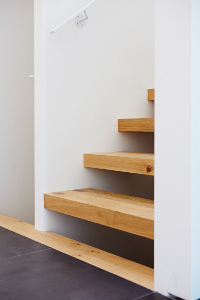 Sixty-five-millimetre–thick stair treads lead to the second storey and the basement. White oak engineered flooring throughout from Stone Tile.