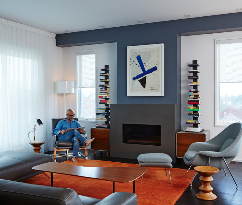 Across the way, in the third-floor living room, a Julian Schnabel resides over the fireplace. Wood/concrete cabinets from Made; rug, chair and floor lamps from DWR.