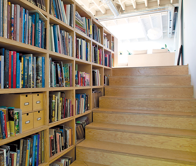 Monkman’s book collection is hidden on shelves that continue around the corner and across the width of the upper space. The material here is doubled-up Douglas fir plywood.