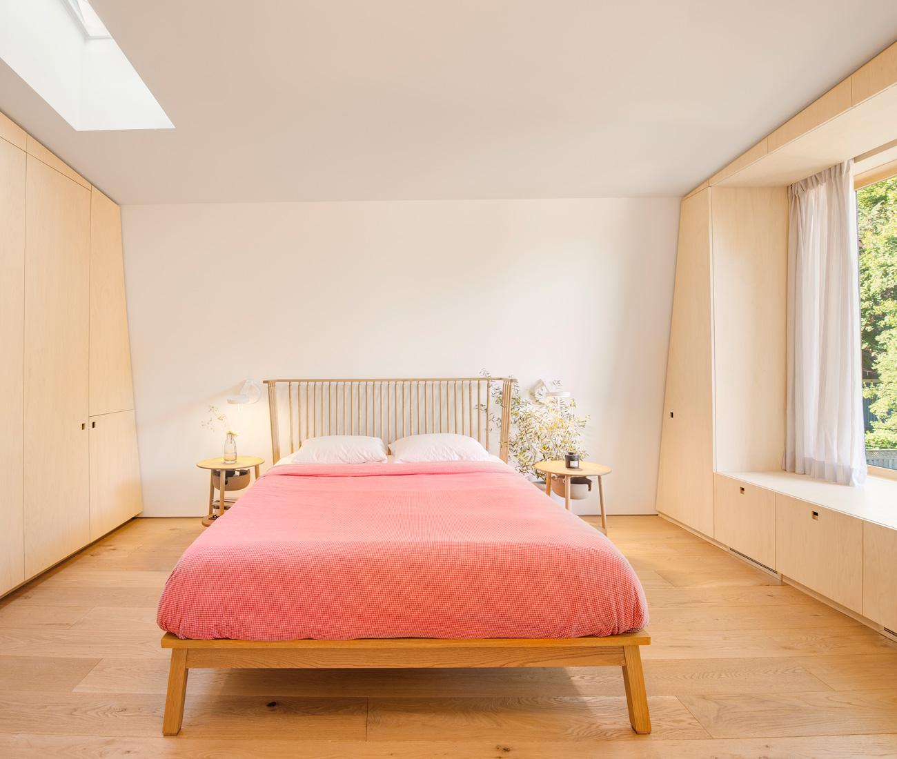 In the master bedroom a metre-wide windowseat overlooks the garden. Side tables and Ilse Crawford bedframe from Mjölk.