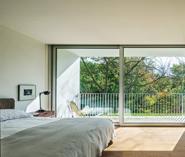 A glazed wall by Door Studio in the master opens up to the second storey–long balcony. Bed from Palazzetti. Photo by Bob Gundu.