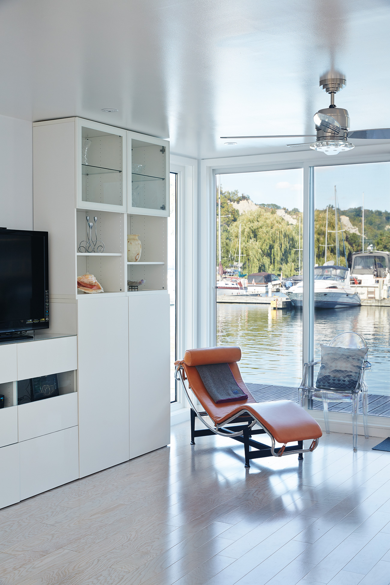 Sliding glass from Canada Windows & Doors maximizes Cheung and Cauldwell’s views of the marina. LC4 Chaise available at DWR; cabinets from IKEA. 