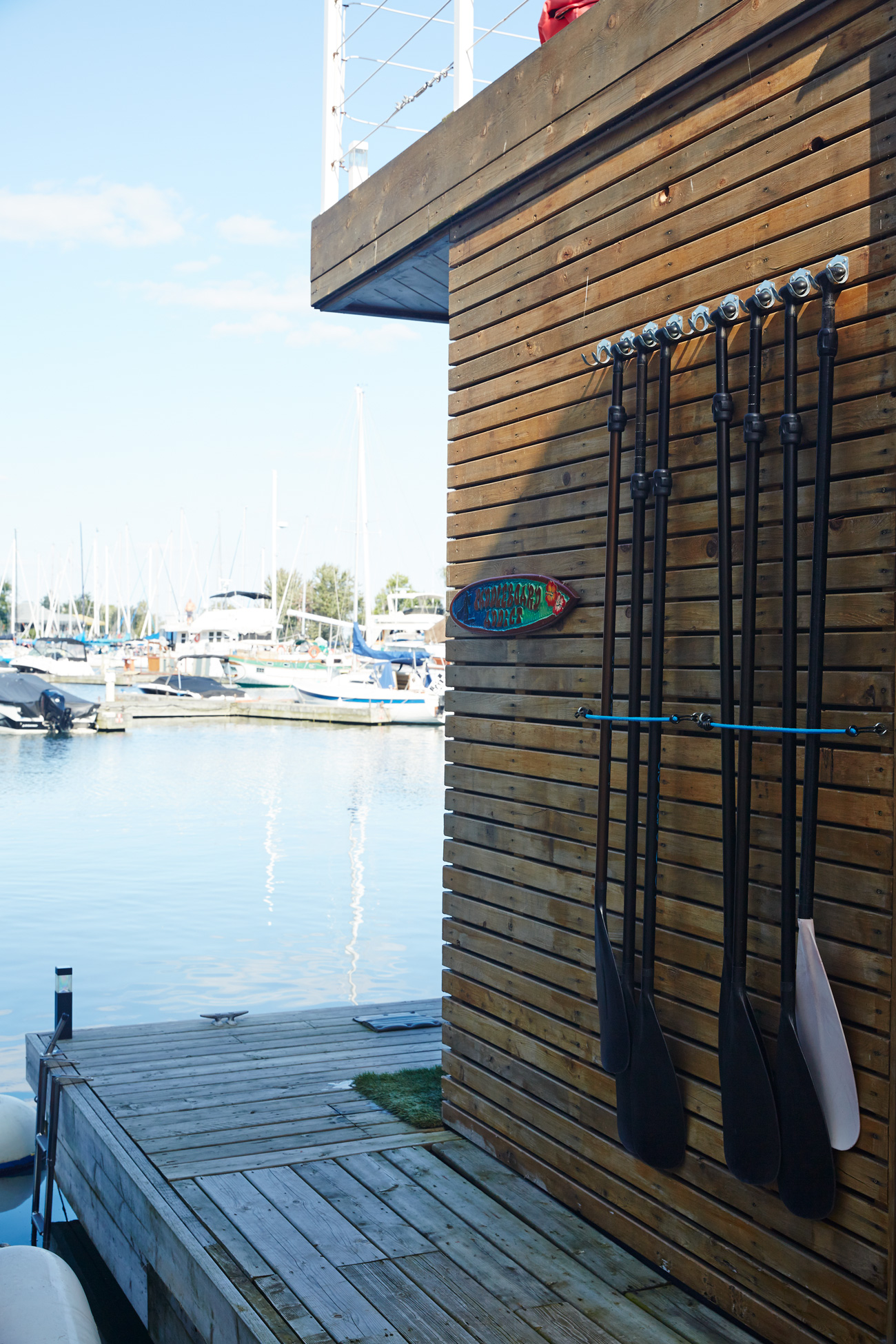 Outside, a cedar-clad wall holds Peic’s paddleboard instruction gear.