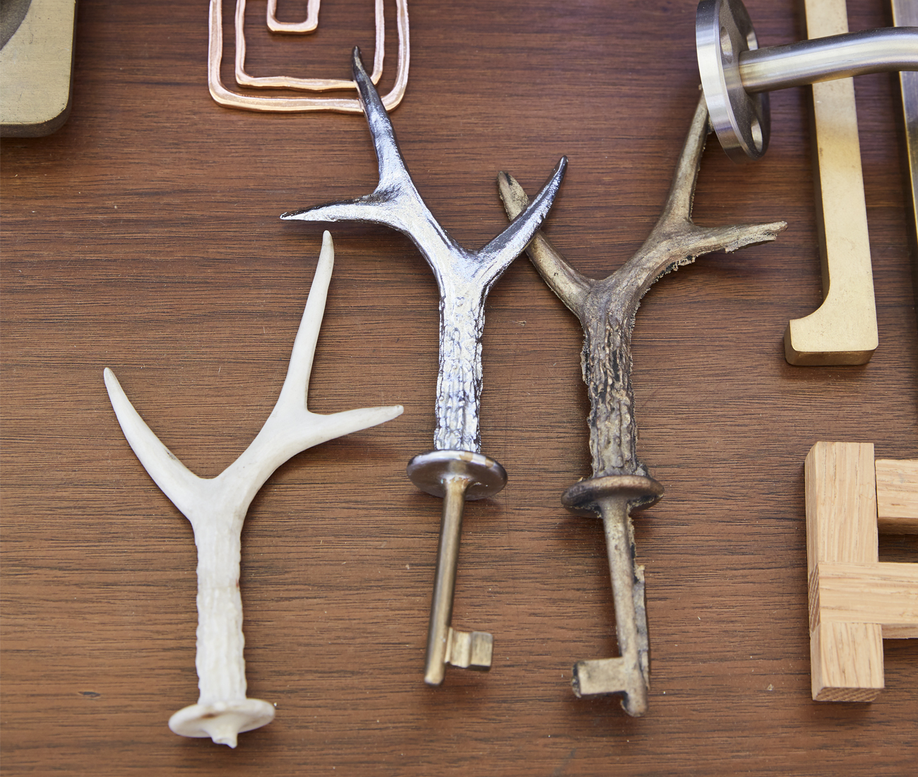 Cast bronze keys sit among custom hinges and handles.