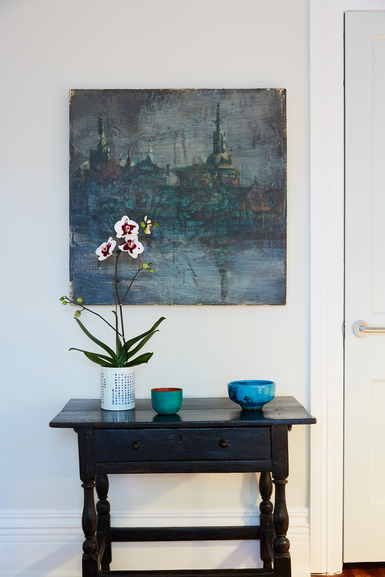 Above the 19th century English Tavern Table hangs an encaustic painting by Tony Scherman.
