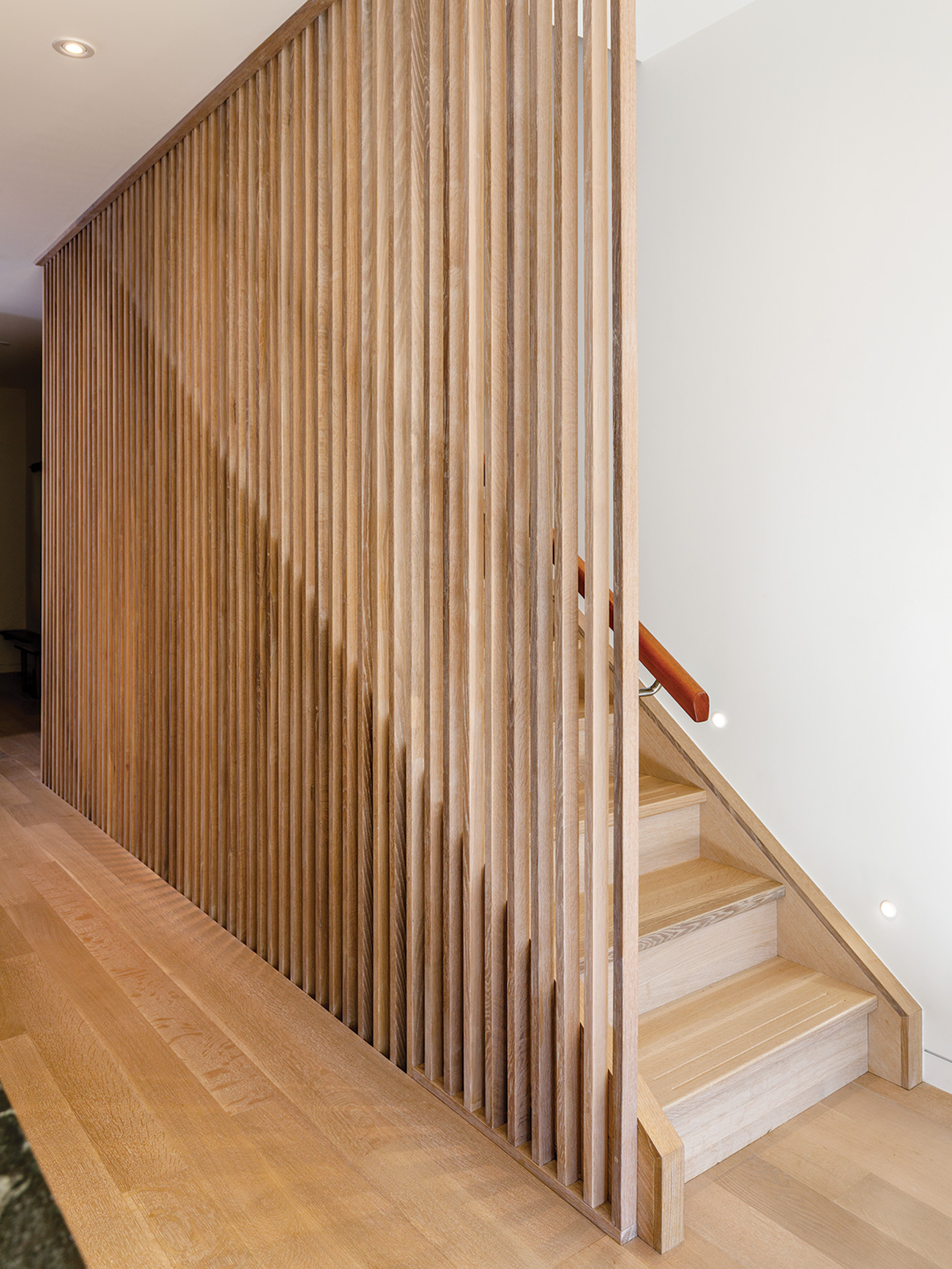 The solid oak staircase features slatted balusters and slip-resistant grooves.