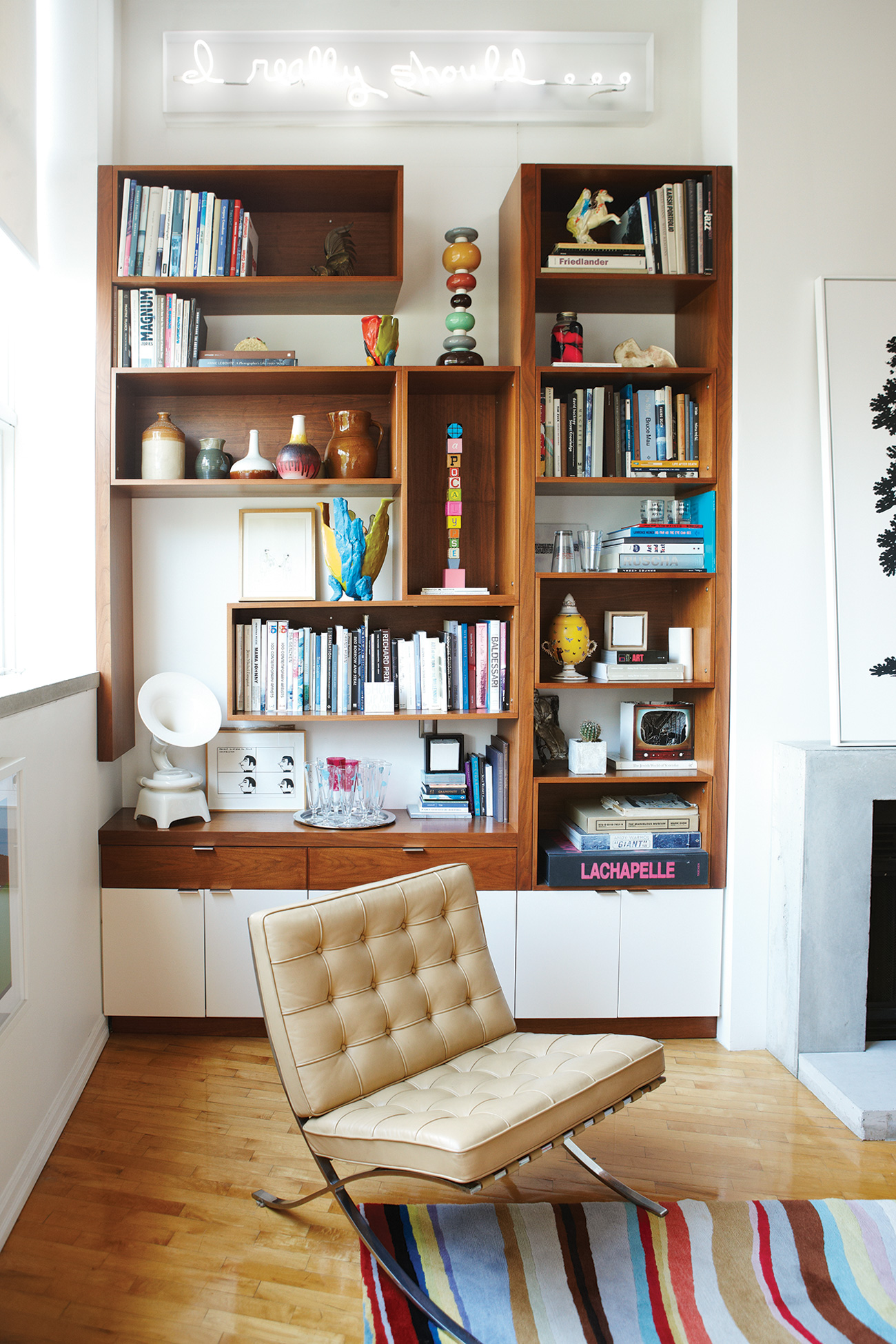 The bookcase contains a number of artworks including a talking stick by Douglas Coupland (centre) and Science & Son’s ceramic Phonophone. Neon sculpture by Kelly Mark.