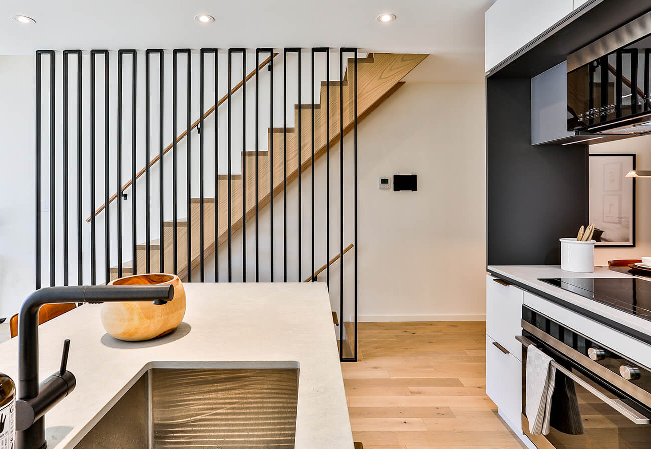 The railing, by Stainless Dimensions not only delineates the stairs from the kitchen but enhances the ceiling height. 