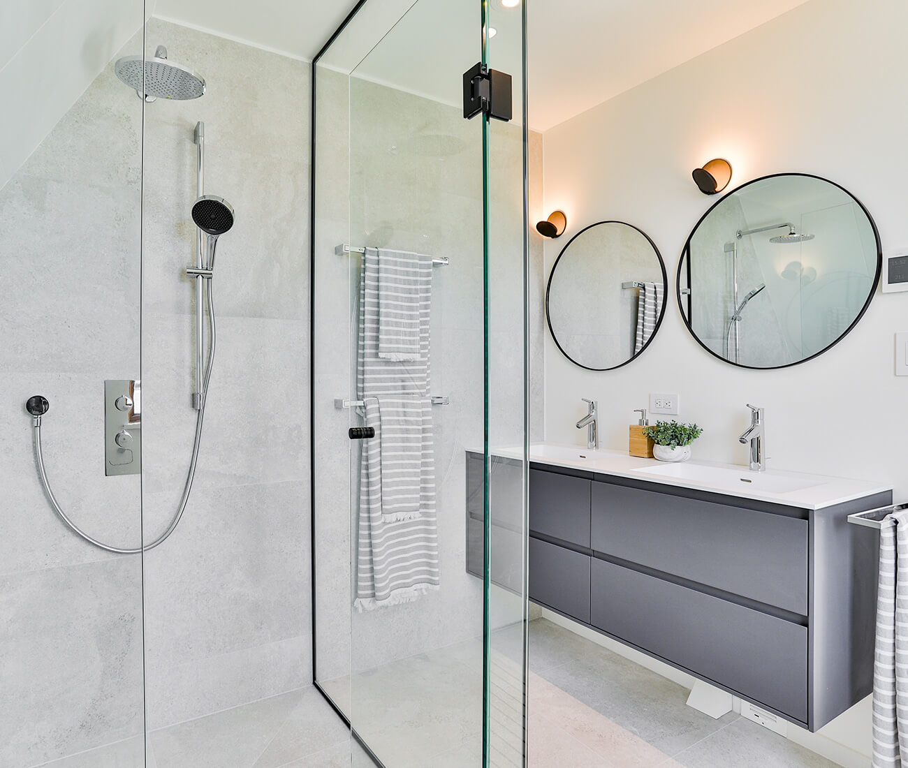 An all-glass shower enclosure by Tiqeq Homes takes centre stage in the master bath. Vanity by Muti; floor and wall ceramic tiles from Stone Tile; sconces from Casa Di Luce.