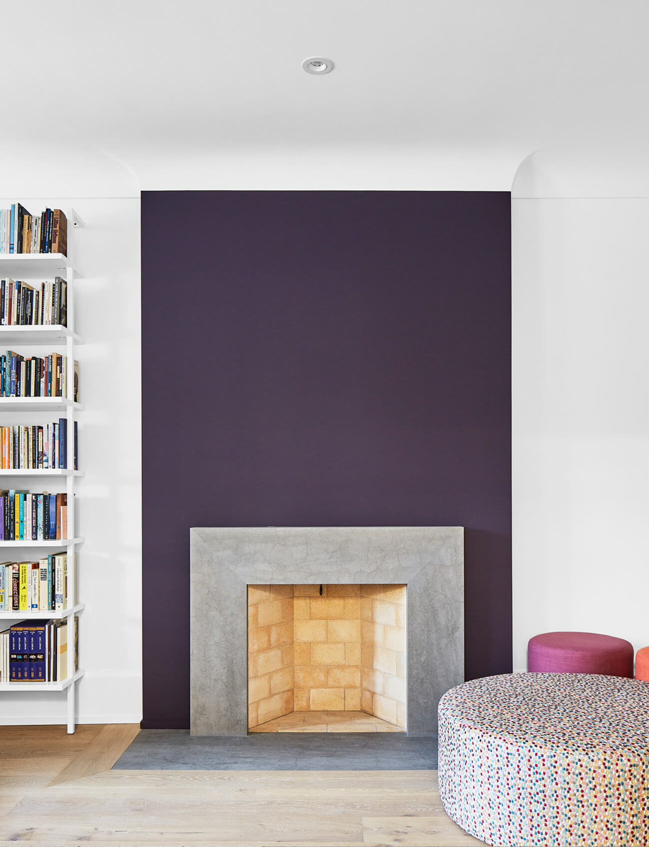 The fireplace was rebuilt to suit the new, sleeker space. A rich purple was used both to offset the home's bright palette, but also to match accents in its original stained glass windows.