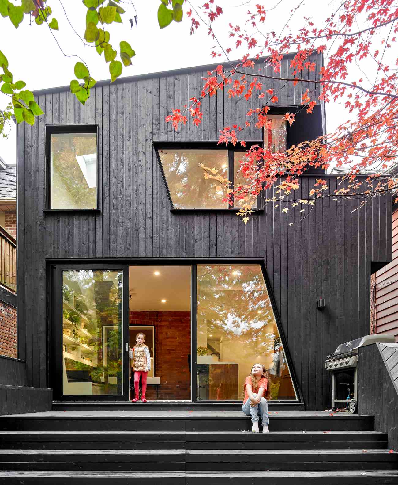 The non-traditional geometry plays off of the Edwardian's gabled roof. The painted black wood cladding is supplied by Cape Cod Finished Wood Siding, while  pressure treated wood was used for the deck and stained black to match.