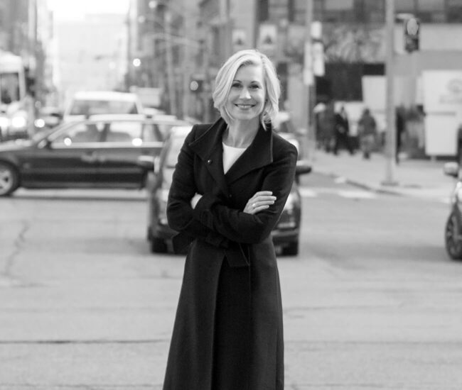 Portrait of urban planner Jennifer Keesmaat standing in the street with her arms crossed