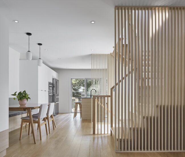 Interior renovation with a wood slat wall providing privacy to the stairs