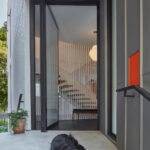 Entrance with dog sleeping on stairs Tile house by Kohn Shnier Architects