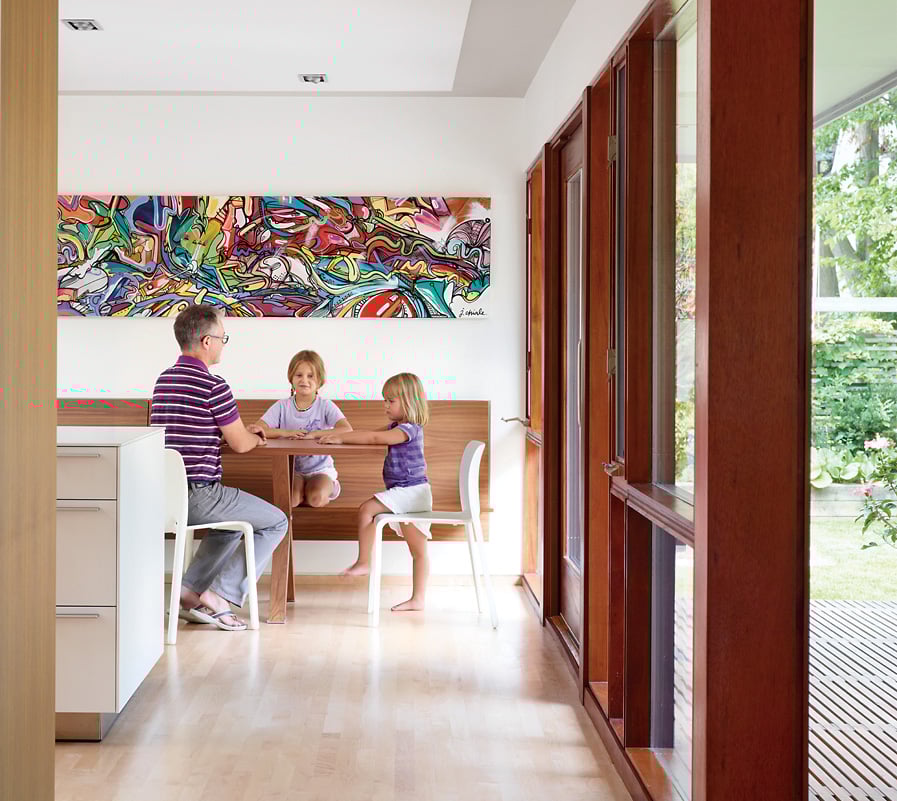 Father and kids sitting at the kitchen table of a 1950s bungalow
