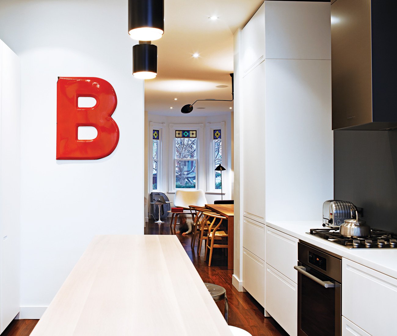 White walls and Boffi kitchen cabinetry contrast with the walnut flooring.
