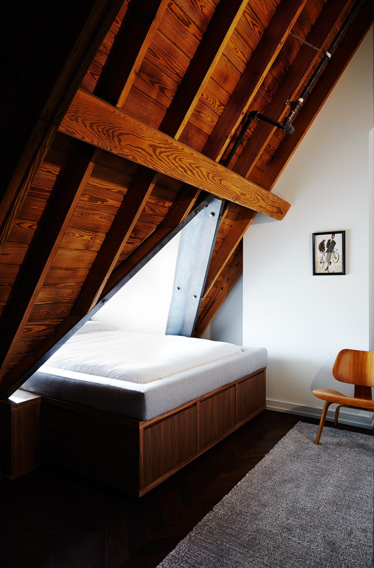 Walnut-veneer storage bed fits snugly under the steel-reinforced dormer at the converted  Neo gothic church condo by Alison Milne