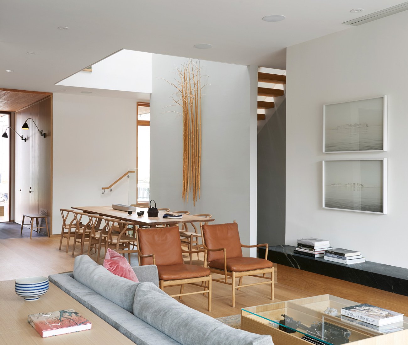 Modern Living room design with couch and chairs while in background a long table is visible - Leaside House by Arriz + Co and Altius Architecture  