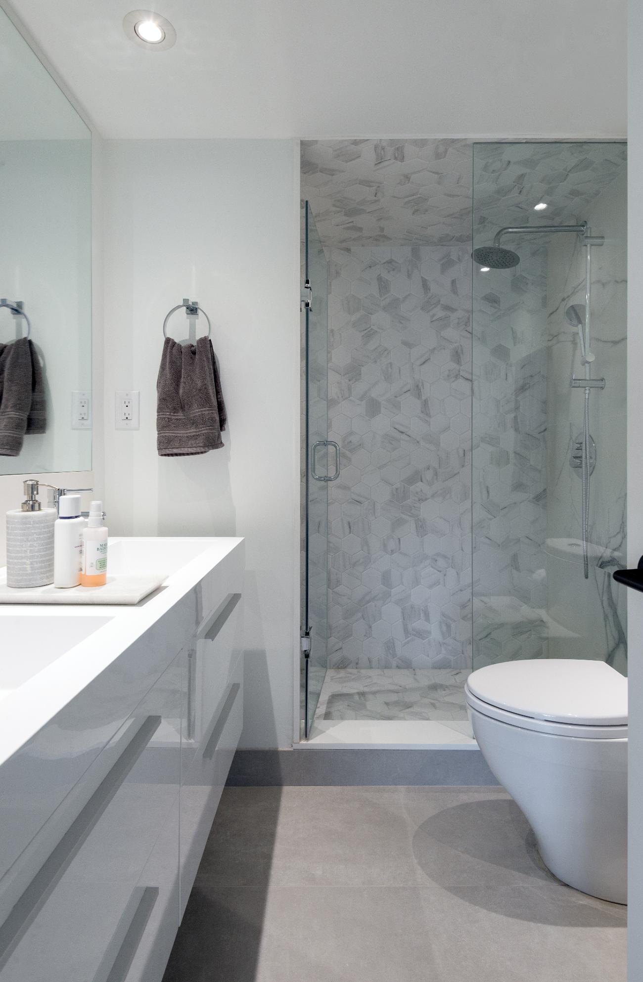 Carrara hexagons in the shower and large-format porcelain for the flooring