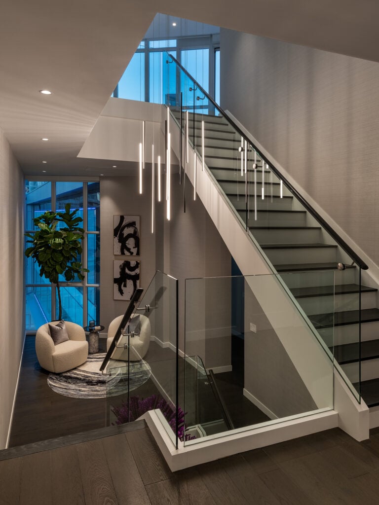 Condo interiors with pendant lights and modern glass stairs in Toronto