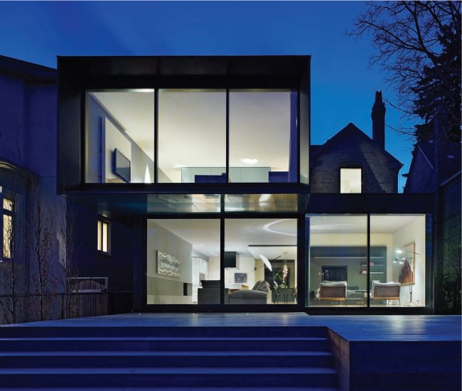 Evening backyard view of a home with large windows