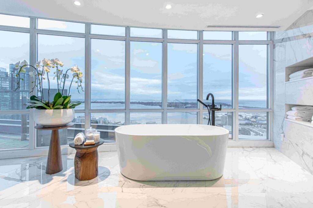Freestanding tub in a condo with gorgeous view of Lake Ontario