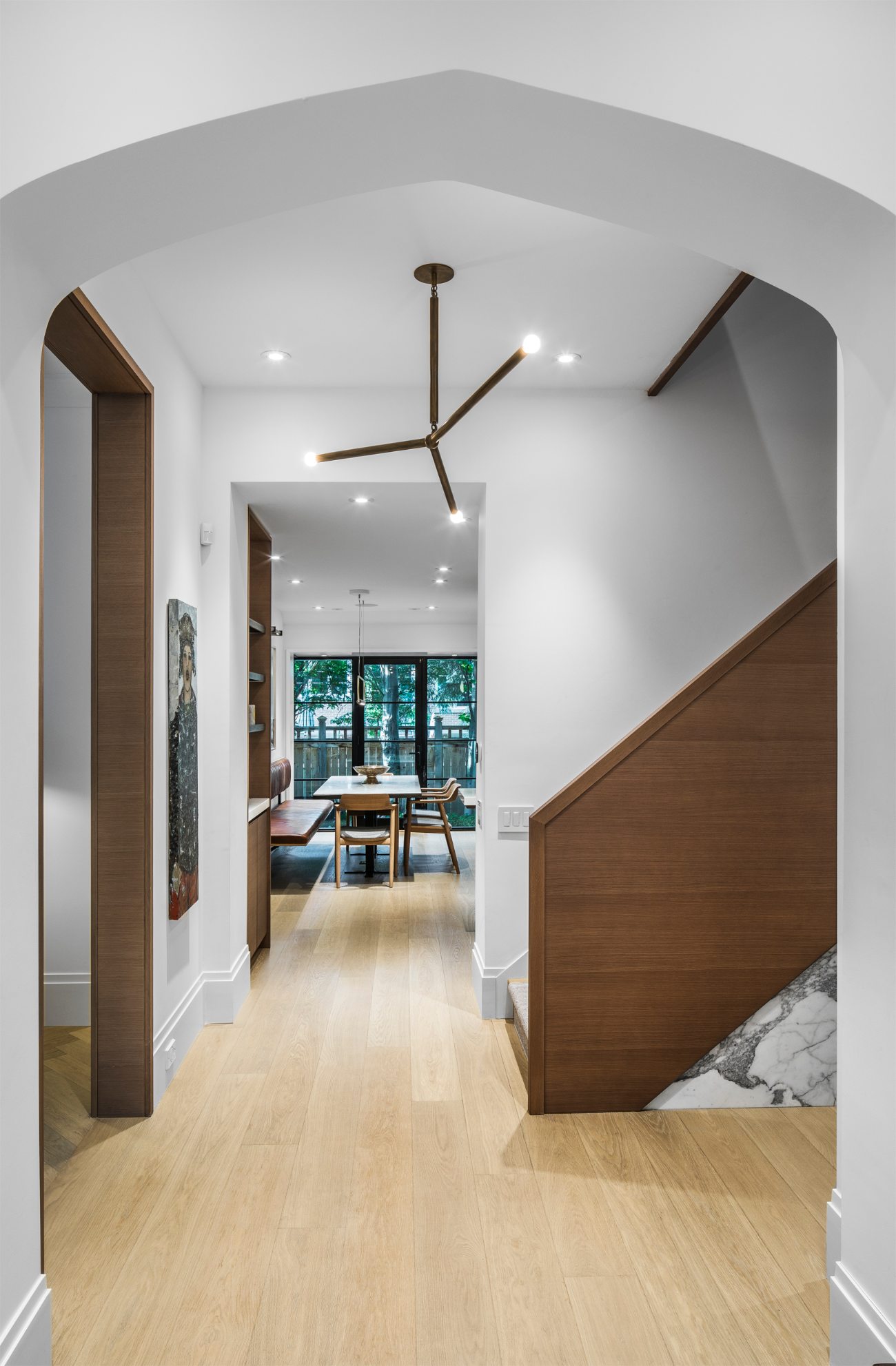 Georgian home Entrance hall, with the central staircase, leading to a kitchen and library, featuring a leather and brass pendant light by Apparatus Studio.