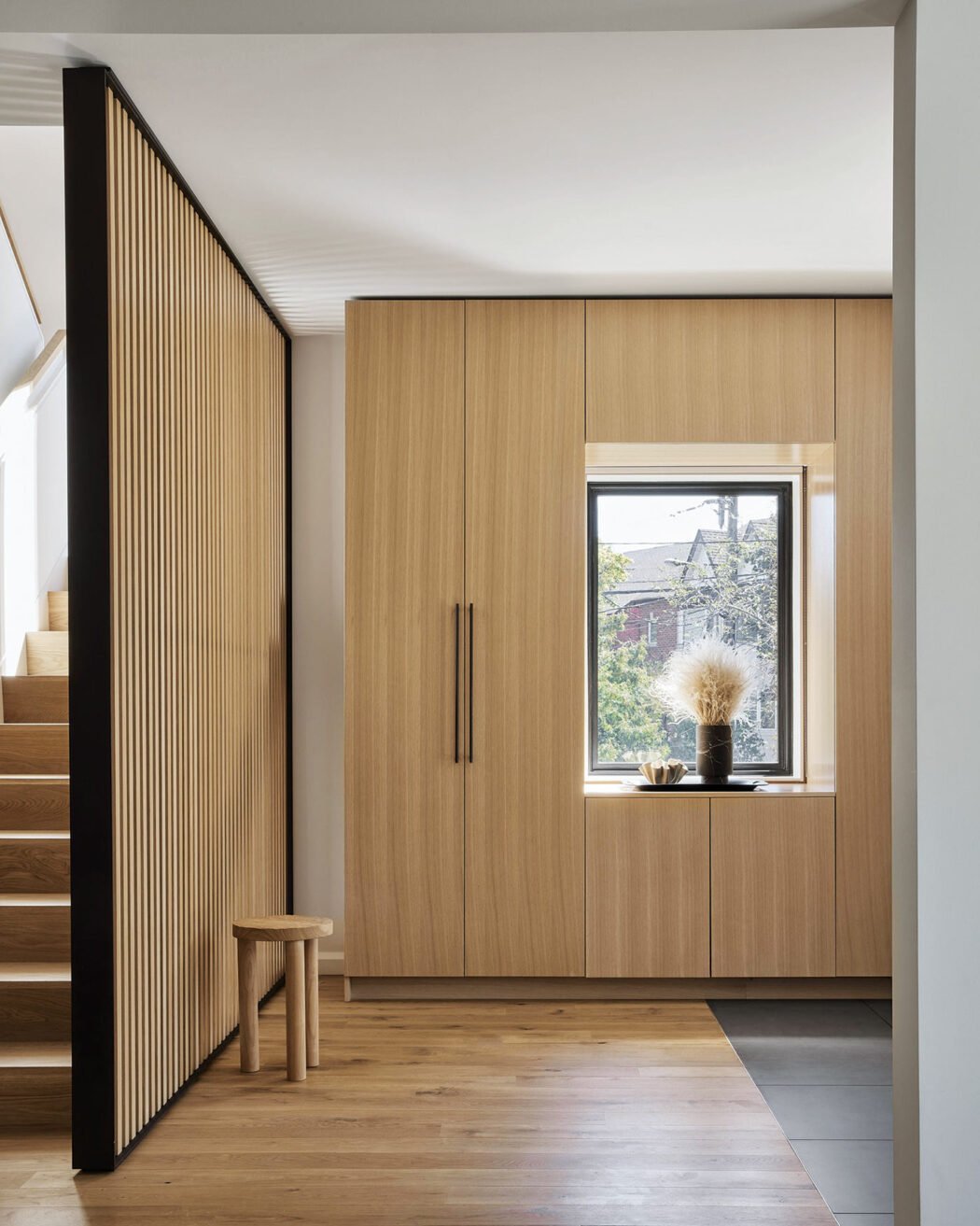Wood slat wall in white oak elegantly delineates space in a home - Toronto architecture firm Superkül