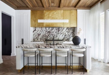 Mixed materials (including a hammered brass vent hood and Calacatta Viola stone) offer a contrasting look without clashing. Bar stools, Simon James; pendant, 1st Dibs.