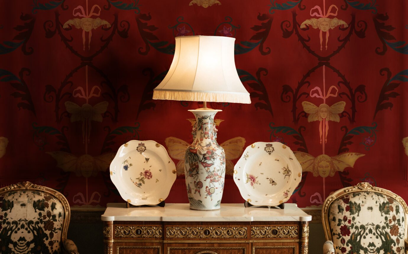 Lamp and two decor plates on furniture, creating a moody Whimsigoth aesthetic.