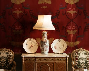 Lamp and two decor plates on furniture, creating a moody Whimsigoth aesthetic.