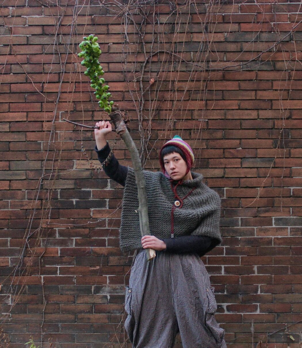 Portrait of Maddie Gnam holding a club made with a brussel sprout stalk