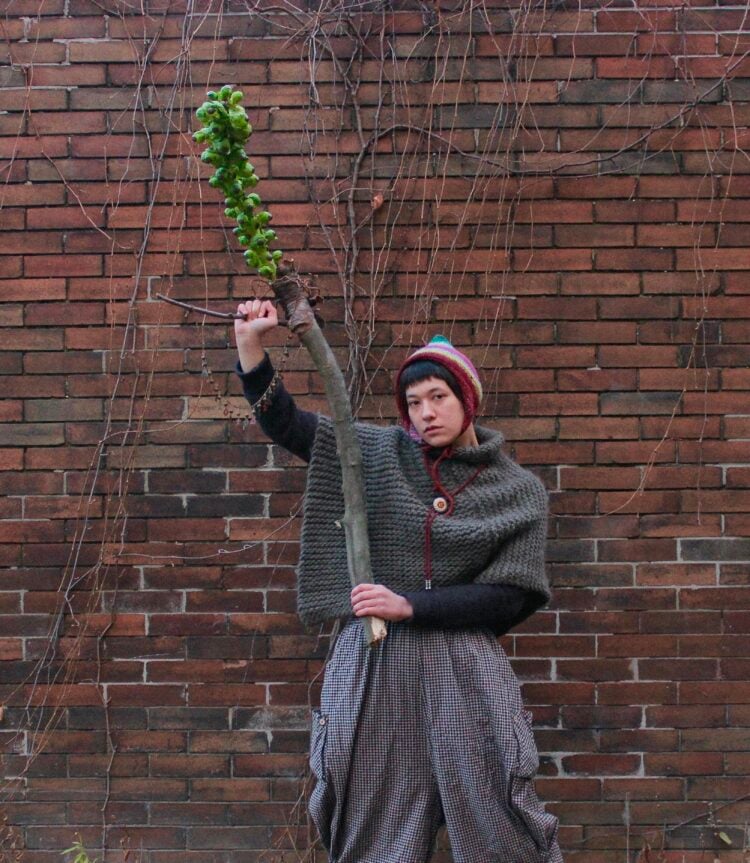 Portrait of Maddie Gnam holding a club made with a brussel sprout stalk